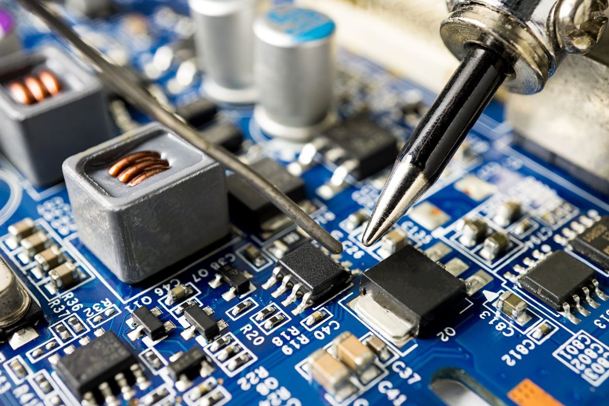 Repair microchip with soldering iron and tin, close up picture